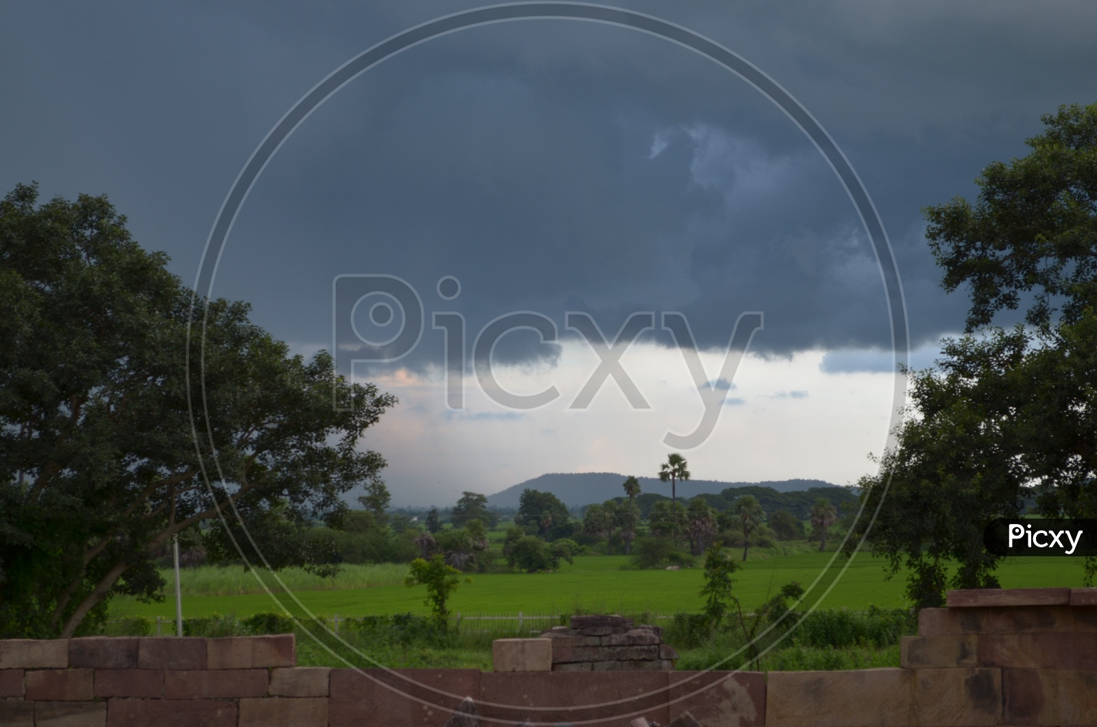 Cloudy Sky With Dark Clouds In Sky At a Agricultural Field