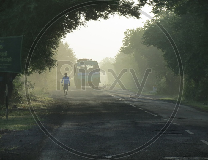 A Public Bus On a Road In Foggy Morning