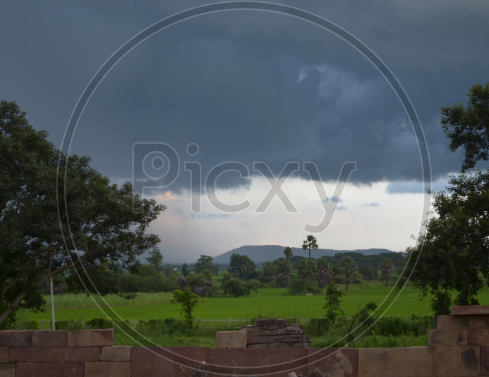 Cloudy Sky With Dark Clouds In Sky At a Agricultural Field