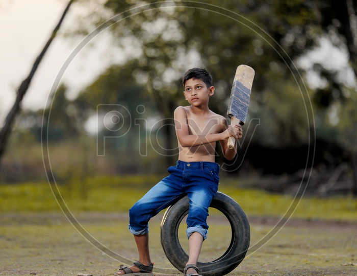 Indian Rural Boy Playing Cricket