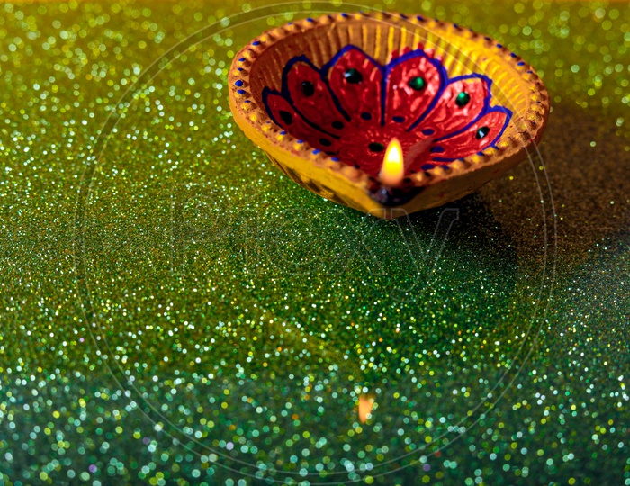 Diwali Indian Festival Diya or lamp with green background / Lightened Up Diya / Diwali Festival of India