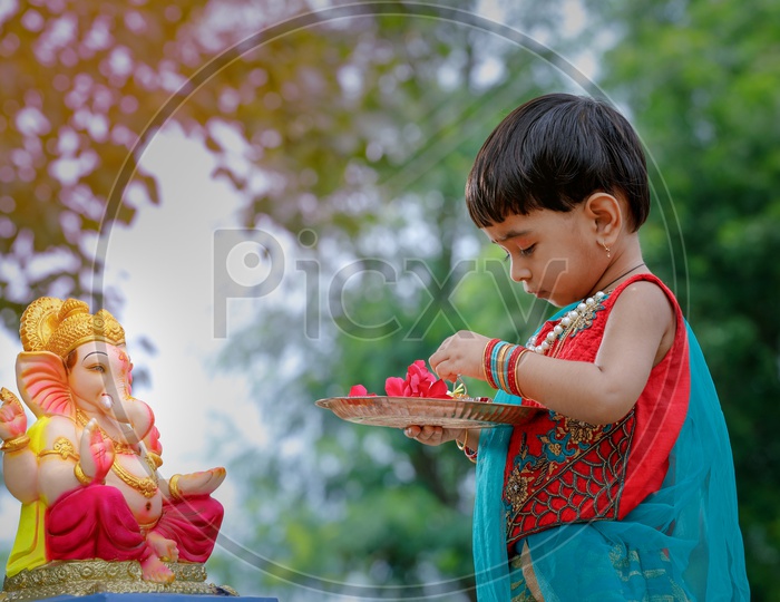 Indian Girl   Child  Offering  Prayer To Hindu Elephant Headed God Lord Ganesh