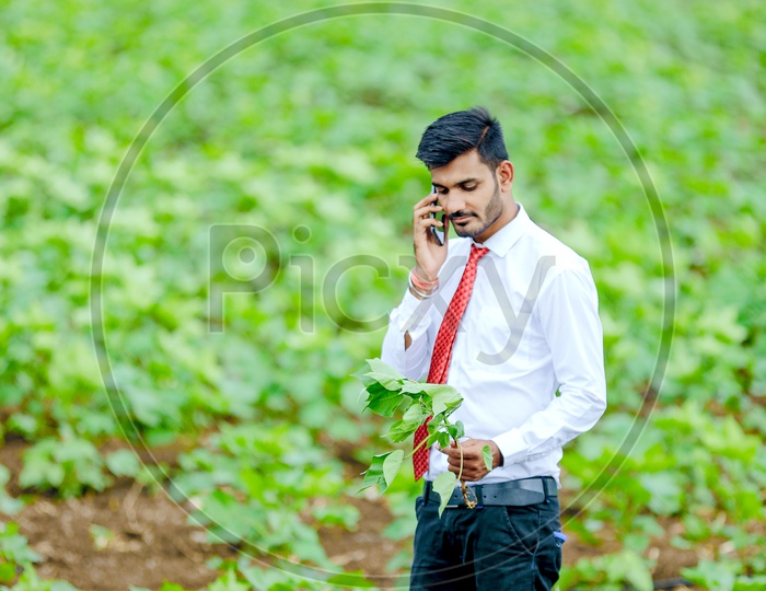 Indian Young Professional Speaking in Phone  In Agricultural Fields