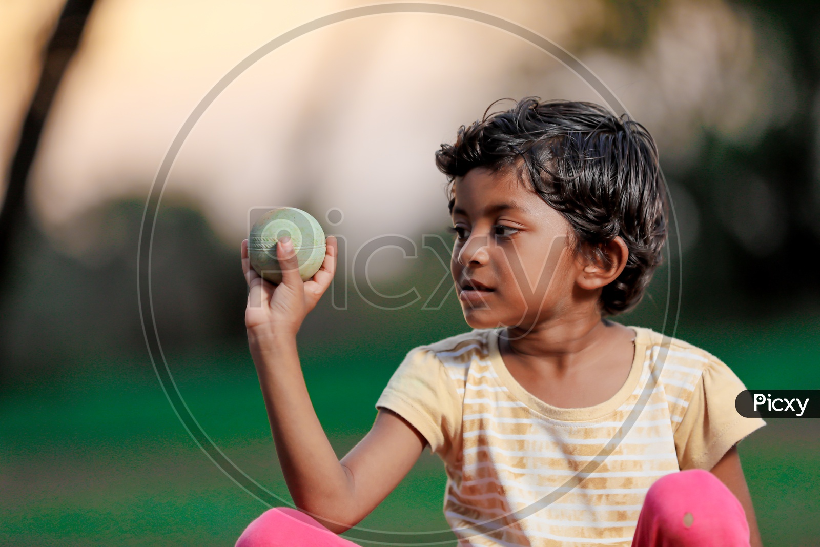 Indian Girl Child Playing with a Cricket ball