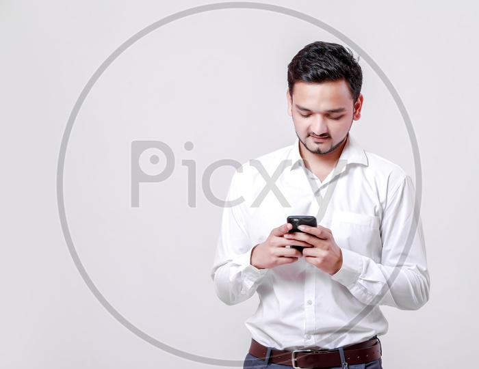 Indian Young Professional Man With a Smiling Face and Using Mobile  On an Isolated White Background