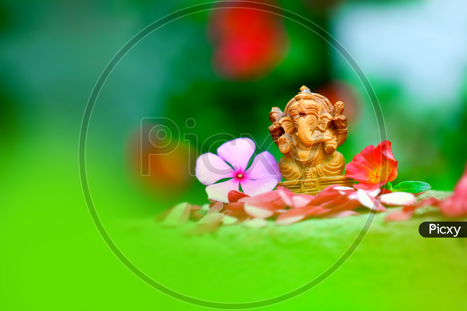 Lord Ganesh Idol  with  beautiful flowers in the foreground and greenery in the background