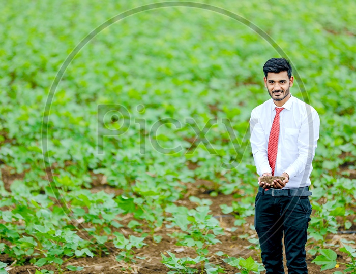 A Young Professional In Agricultural Field With Soil in Hand