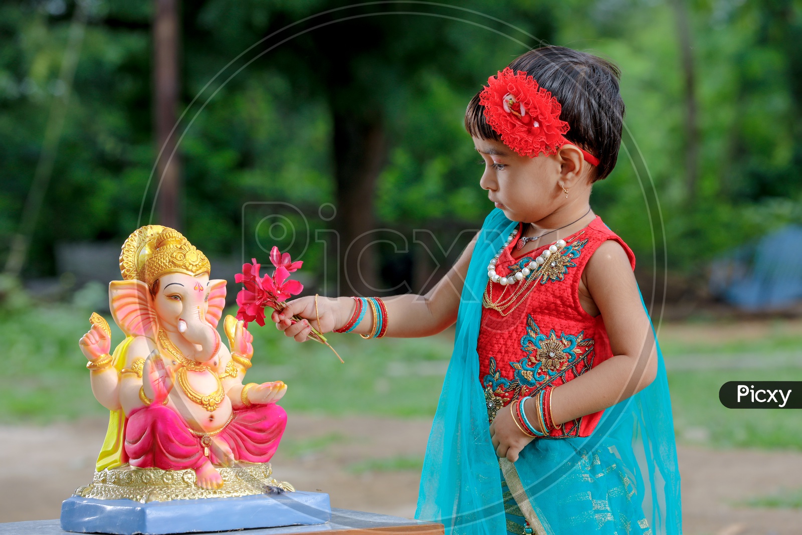 Indian Girl Child Offering  Prayer To Hindu Elephant Headed God Lord Ganesh