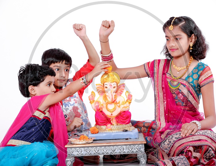 Indian  Children  Offering  Prayer To Hindu Elephant Headed God Lord Ganesh