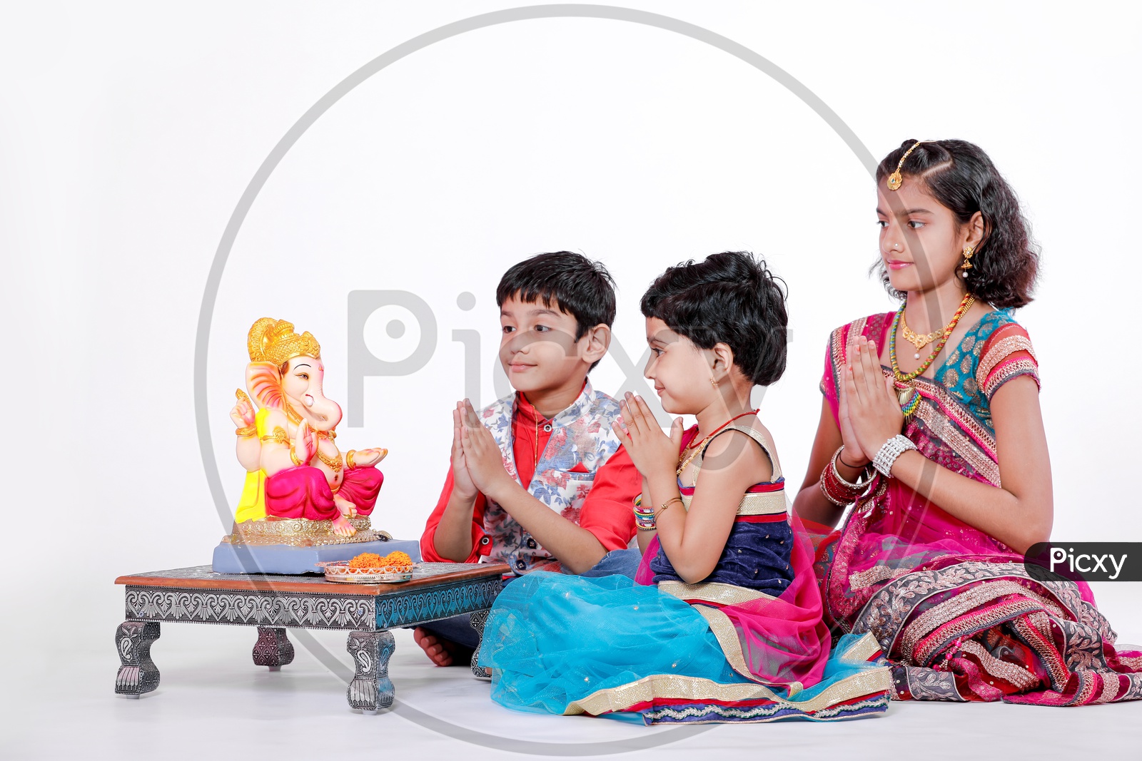 Indian  Children  Offering  Prayer To Hindu Elephant Headed God Lord Ganesh