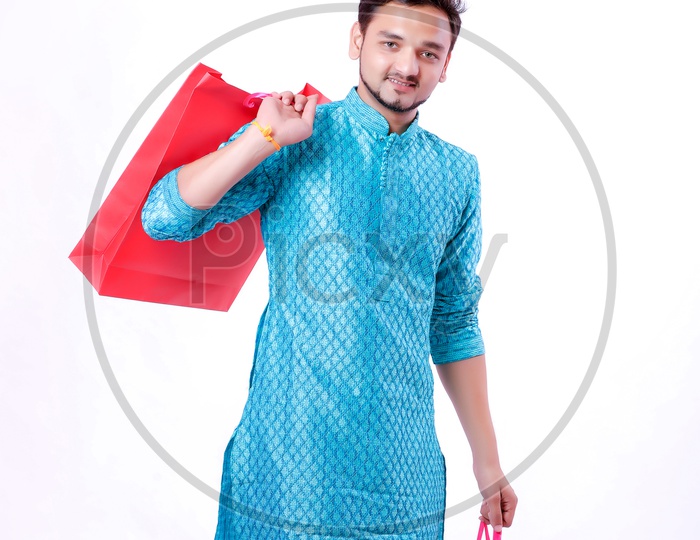 Portrait of a happy Indian Man carrying shopping bags with white background