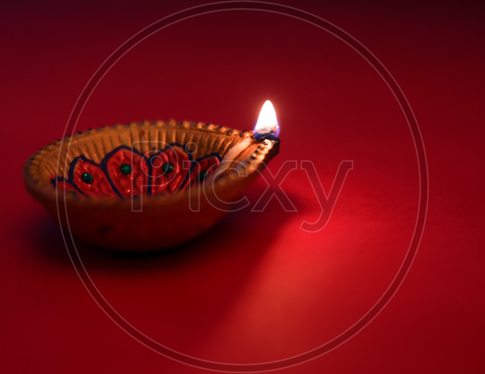 Diwali diya or lamp on red color background
