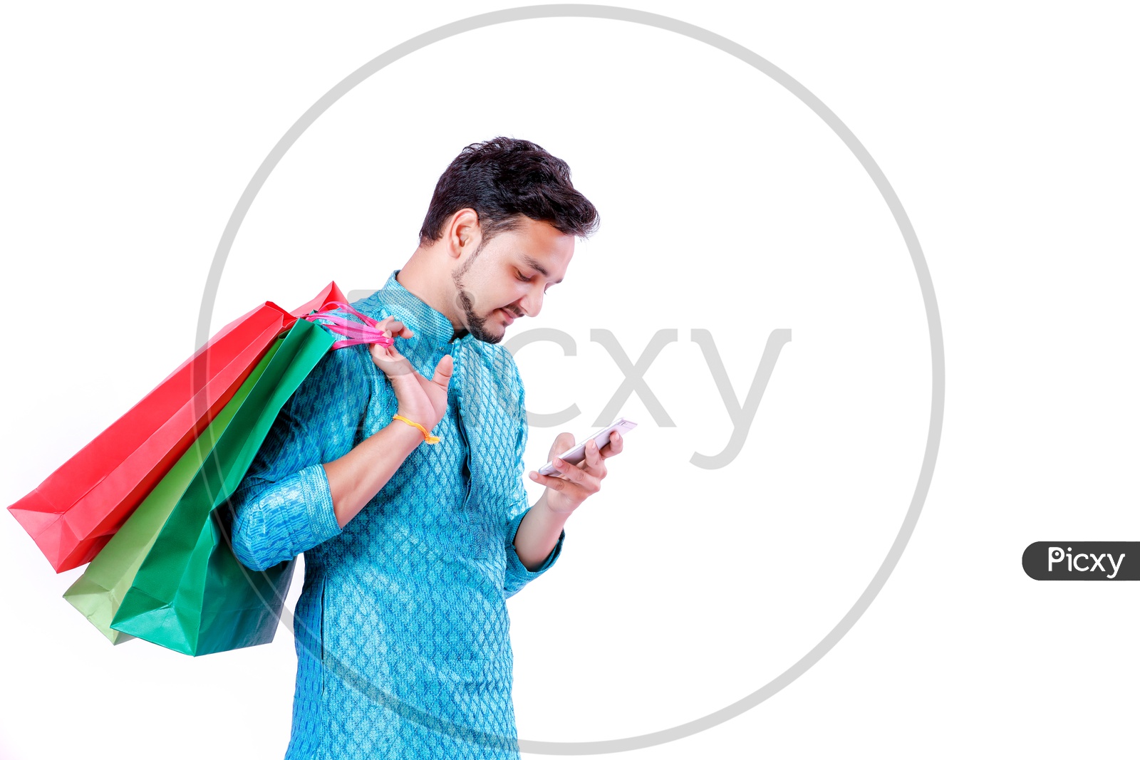 Portrait of a happy Indian Men carrying shopping bags  and looking into mobile with white background