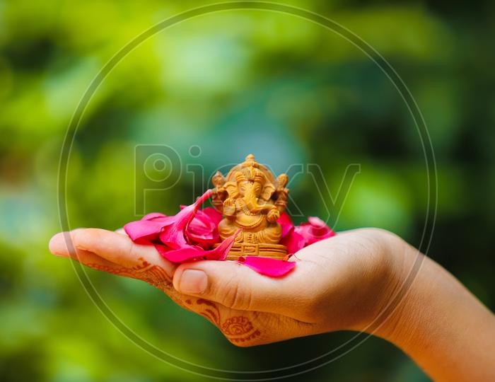 Ganesh Idol placed in palm and beautiful greenery in the background