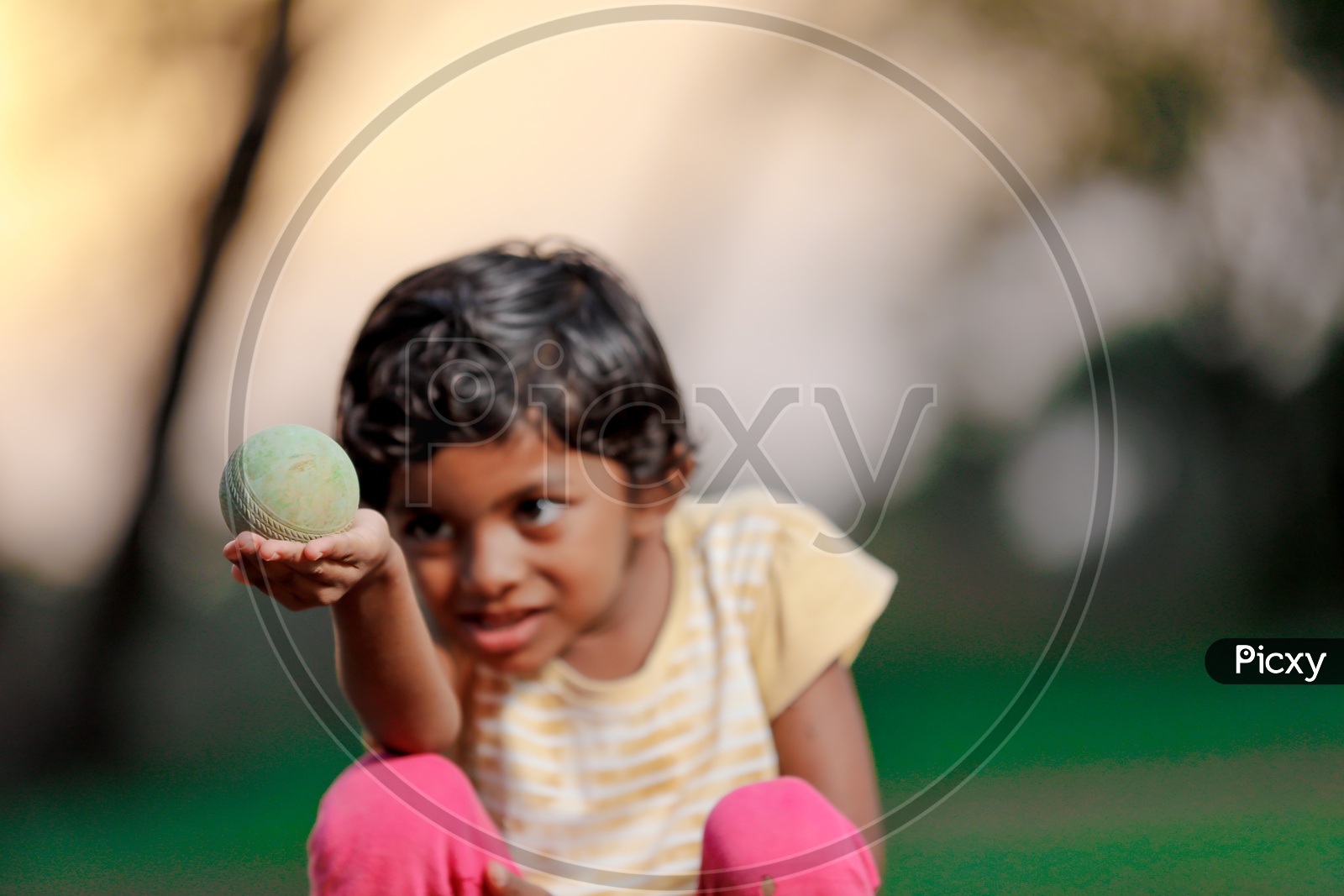Indian Girl Child Playing with a Cricket ball