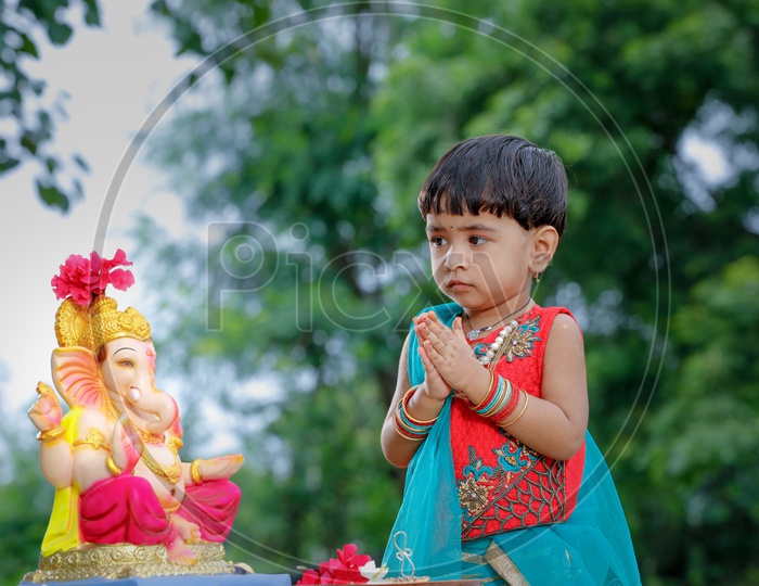 Indian Girl   Child  Offering  Prayer To Hindu Elephant Headed God Lord Ganesh