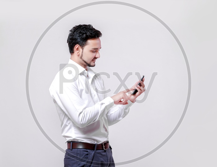 Indian Young Professional Man With a Smiling Face and Using Mobile  On an Isolated White Background