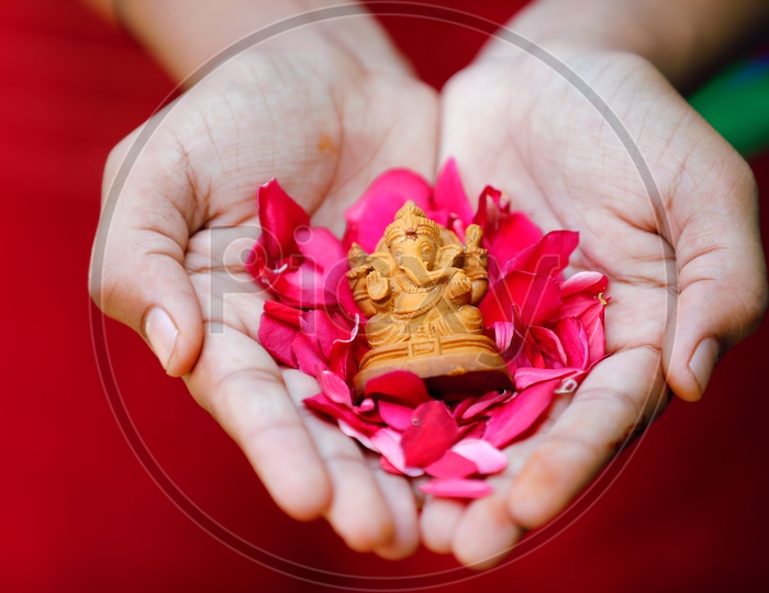 Ganesh Idol placed in hands with  beautiful flowers