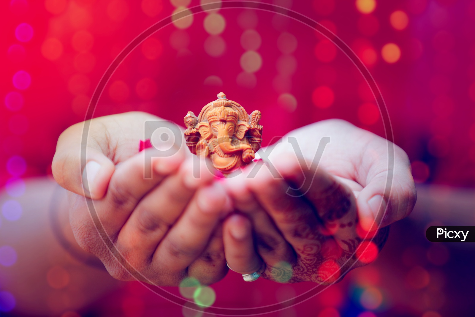 Ganesh Idol placed in Hands with beautiful bokeh in the background  / Lord Ganesha