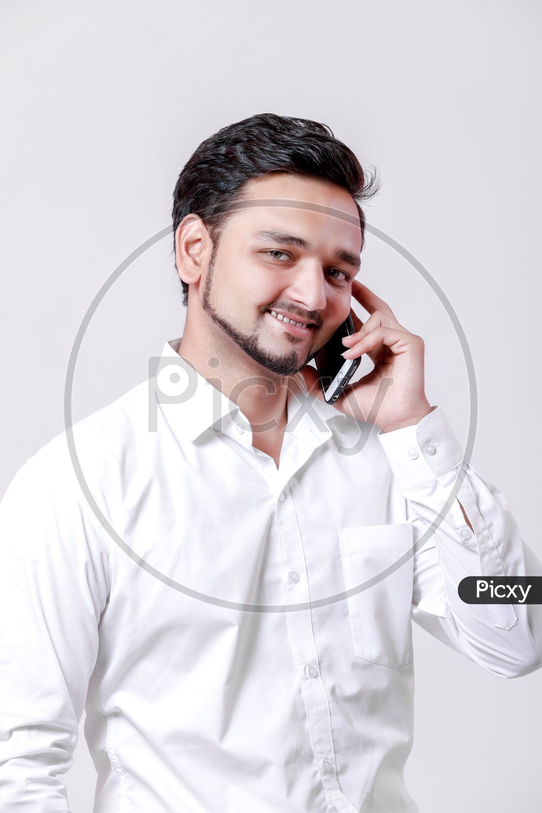 Indian Young Professional Man With a Smiling Face and Speaking in Mobile  On an Isolated White Background