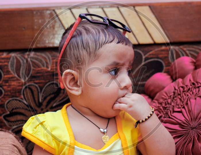 Indian Cute Baby With Cute  Expression on Face and  Wearing Spectacles