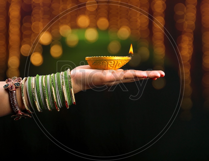 Indian Festival Diwali Lamp / Diya in Indian Women Hands CLoseup Shot