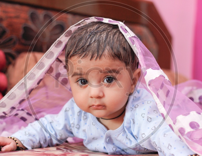 Indian Cute Baby Boy Lying On Bed With A Cute Expression On Face Closeup shot