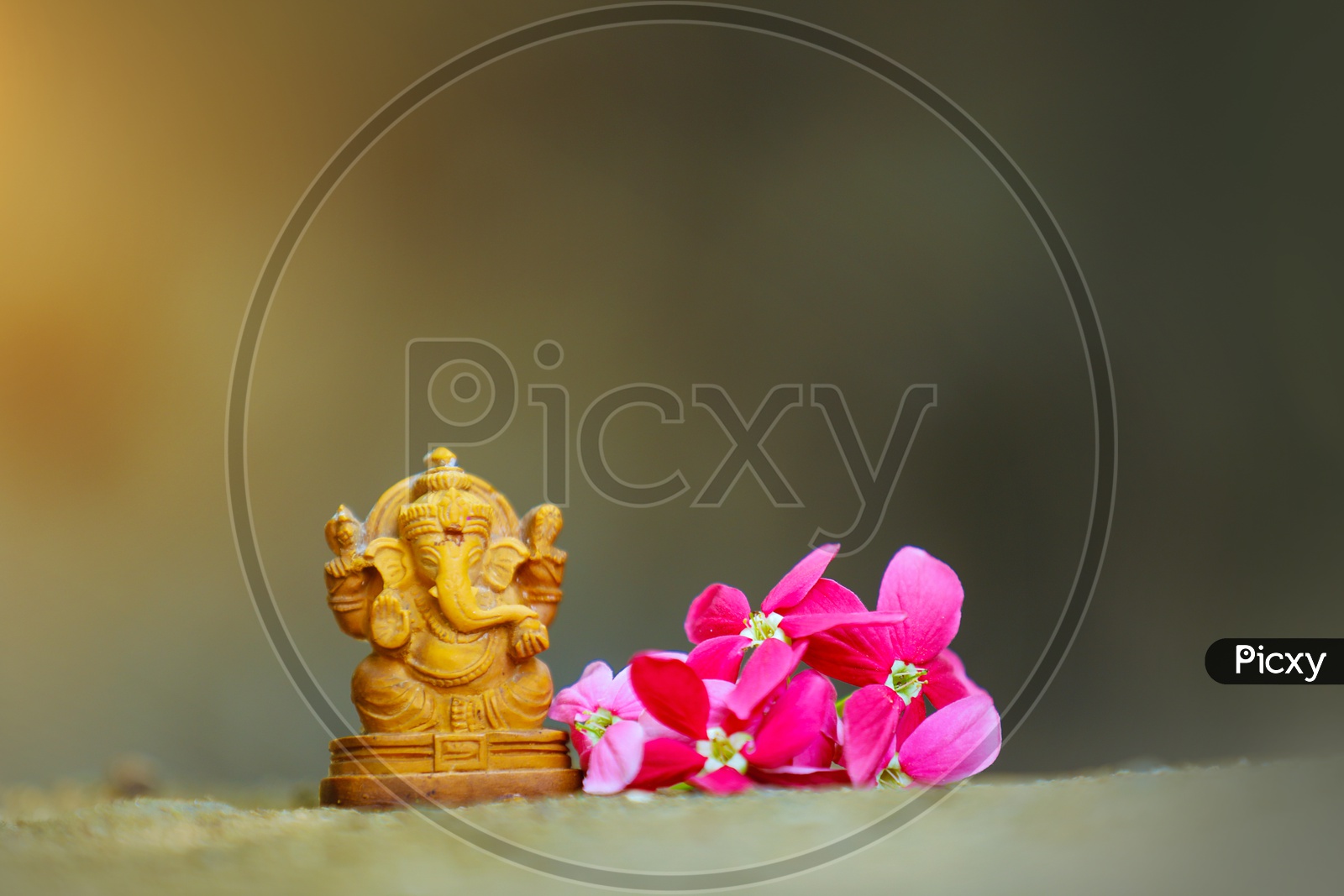 Lord Ganesh Idol  with  beautiful flowers in the foreground / Ganesha Idol