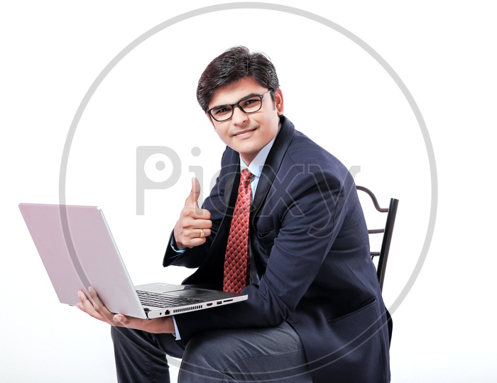 Indian Young Professional Man In Suite Holding Laptop in Hands  With a Smiling Face