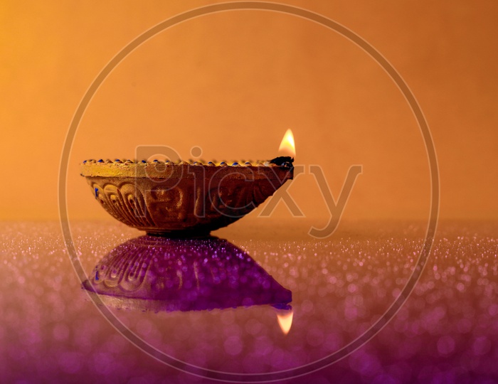 Diwali Indian Festival Diya or lamp with orange background / Lightened Up Diya / Diwali Festival of India