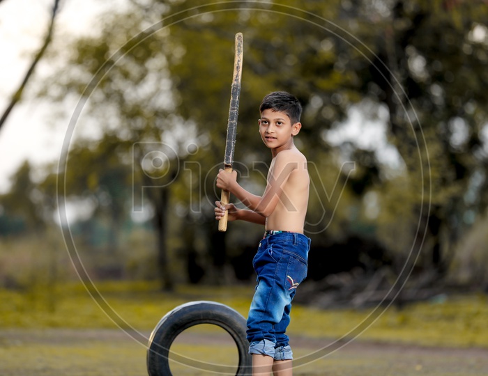 Indian Rural Boy Playing Cricket