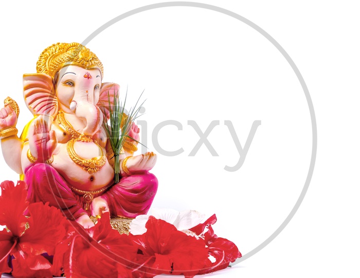 Lord Ganesh Idol with red flowers in the foreground