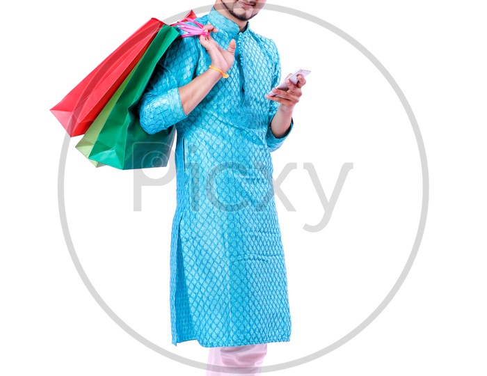 Portrait of a happy Indian Men carrying shopping bags and mobile in hand with white background