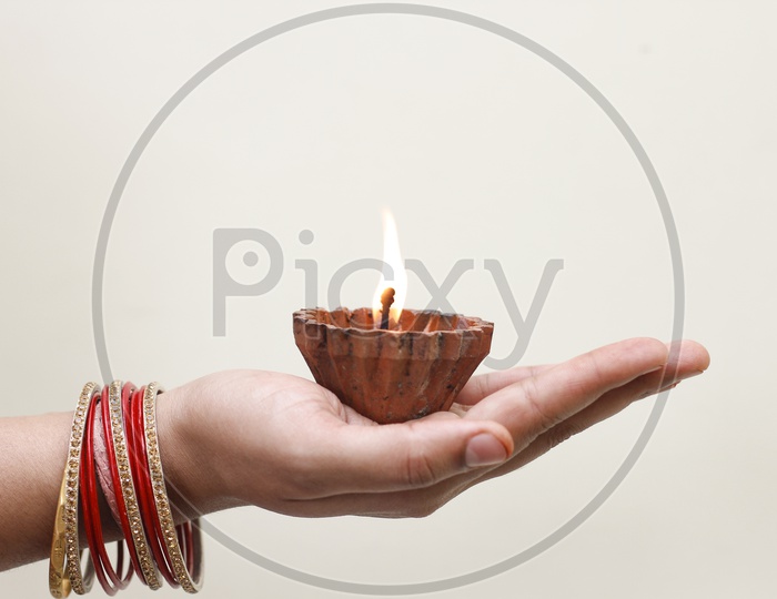 Indian Women Holding  A Diwali  Lamp/ Diya in Hand  Closeup Shot on a White Background