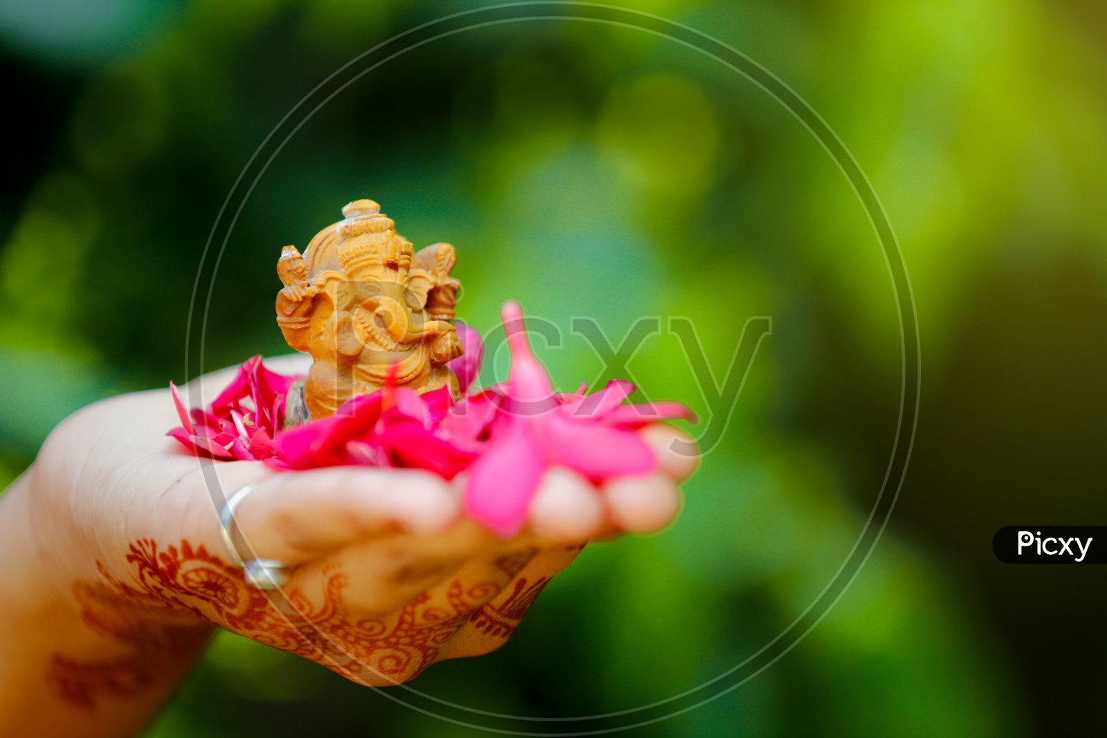 Image of Ganesh Idol placed in palm and beautiful greenery in the ...