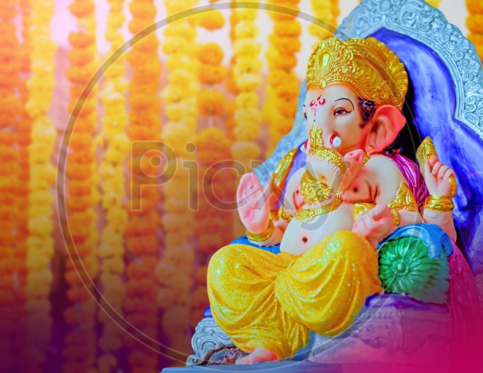 Lord Ganesha Idol with flowers in the background
