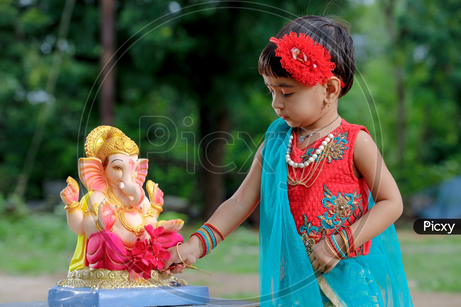 Indian Girl Child Offering  Prayer To Hindu Elephant Headed God Lord Ganesh