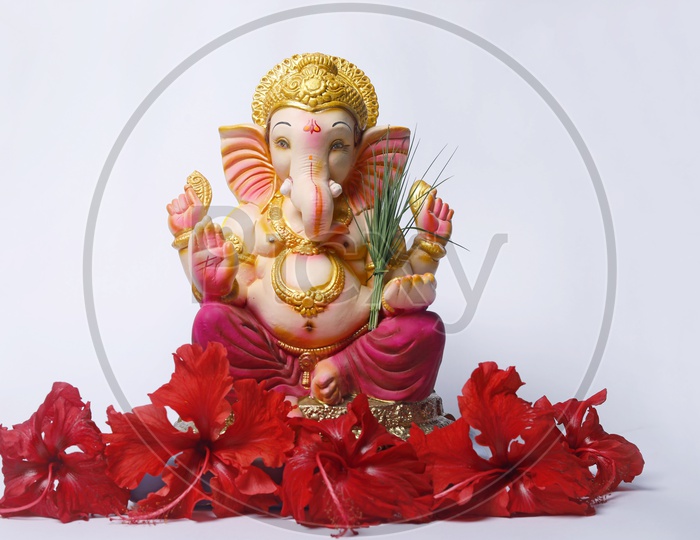 Lord Ganesh Idol with red flowers in the foreground