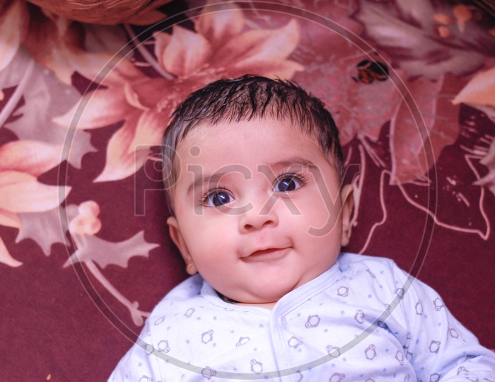 Indian Baby Boy Lying On Bed and Smiling