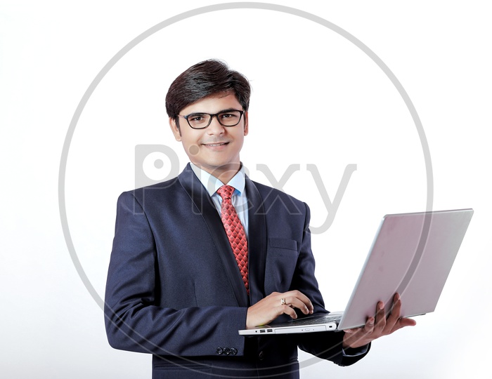 Indian Young Professional Man In Suite  with Laptop in Hand and Smiling Face