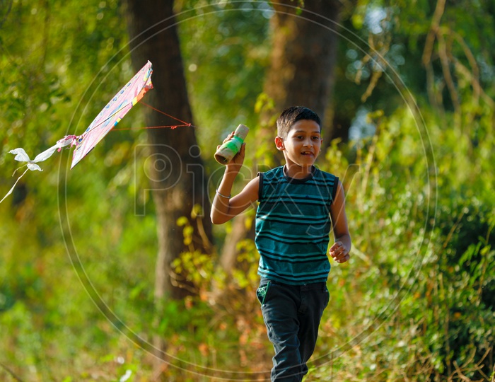 Indian Rural Boy Playing With Kite in Paddy Fields