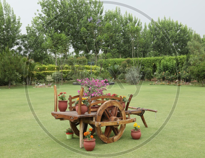 A Model Bullock Cart in a  lawn With Flower pots