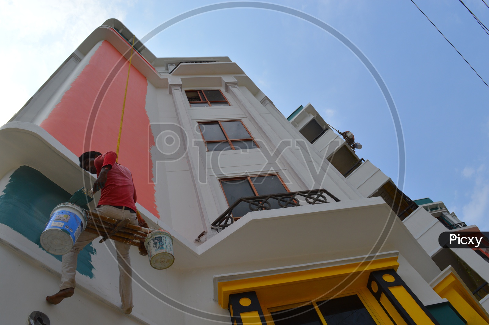 A Worker Painting a Building