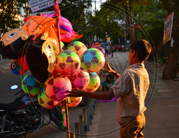 A  Small Boy vendor Selling toys on a Road