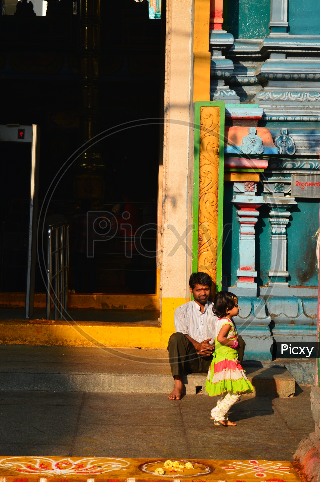 A Man With His Daughter Sitting In a temple
