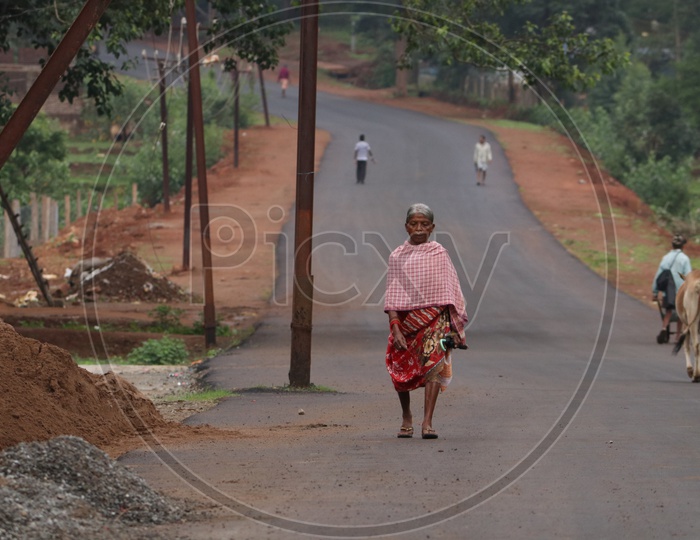 An Old Woman Walking on a Road