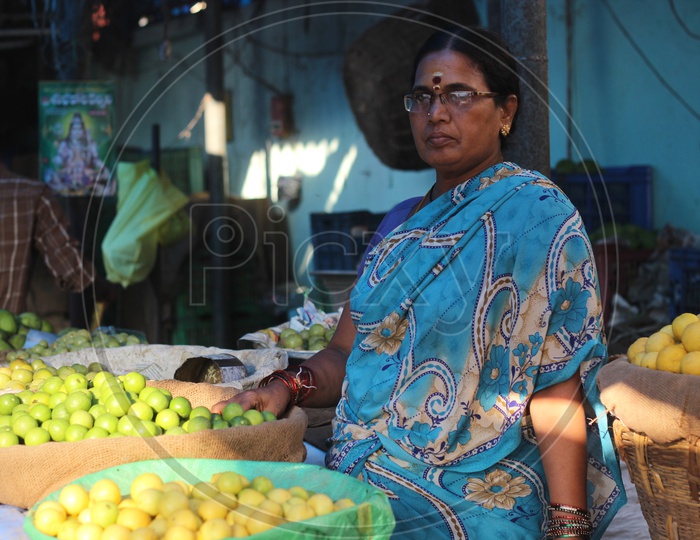 Woman seller at Vegetables Market - Lemons and Gooseberries