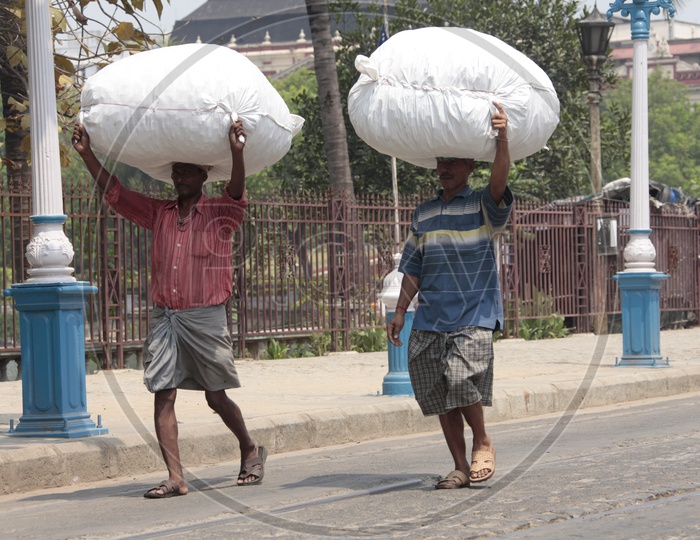 Indian Man Carrying Heavy Weights  Over Their Heads  On The Roads Of India