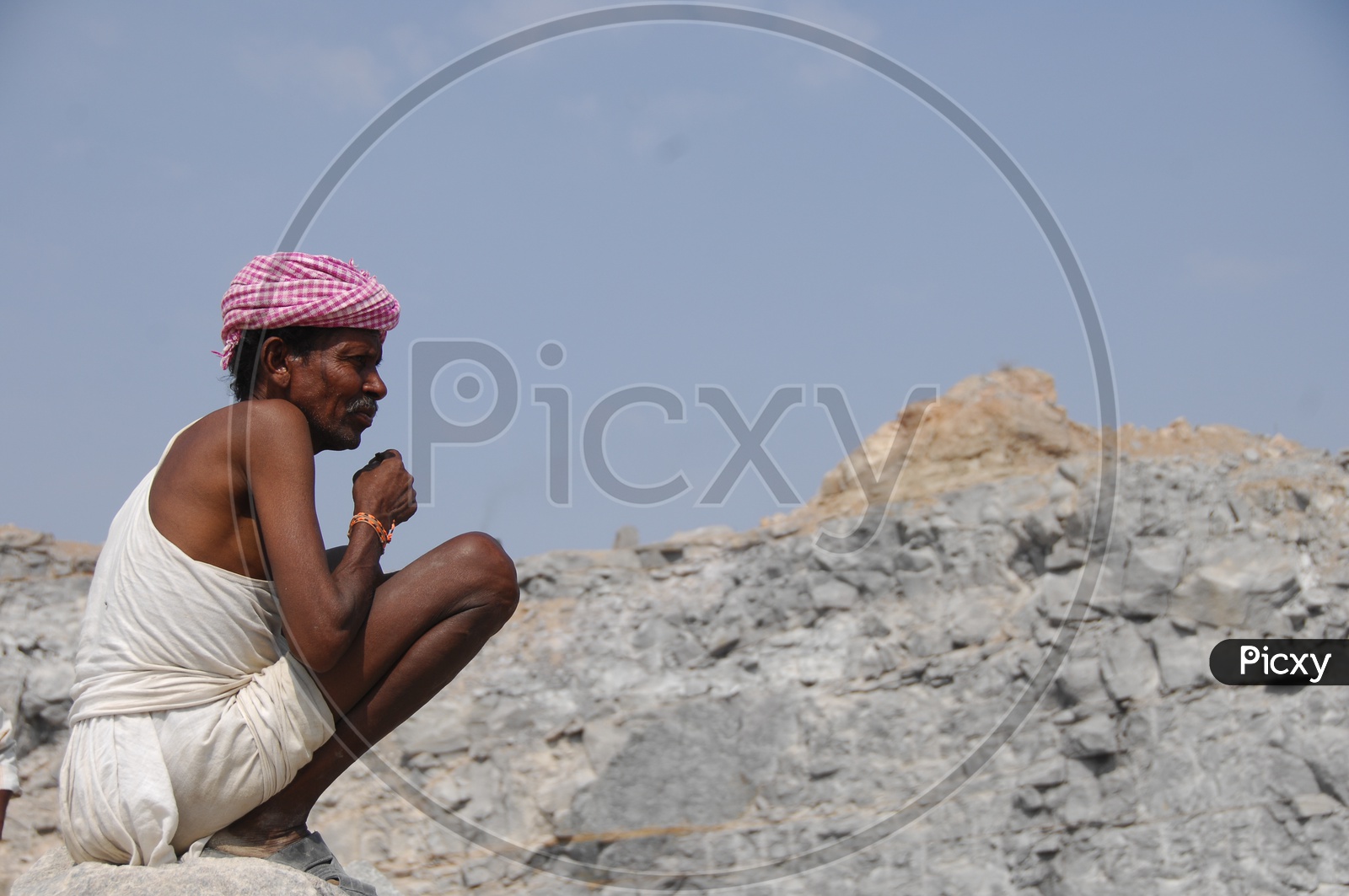 An Old Man Sitting on a Rocks of a Quarry