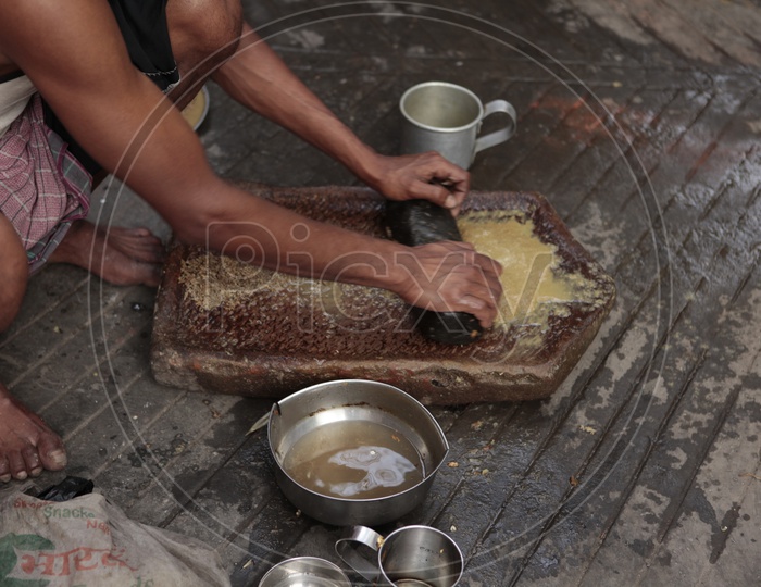 Indian Man Making a Masala on a Traditional Stone grinder